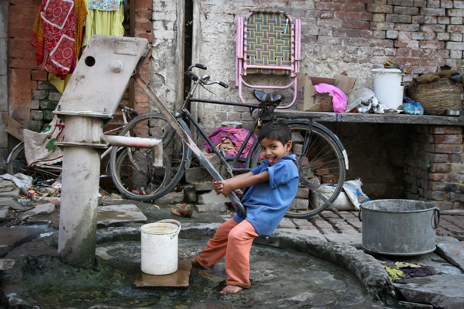 Boy fills up his bucket in Varanasi, India (c) Bart Coolen